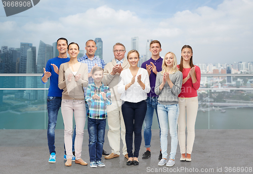 Image of group of people applauding over city waterside