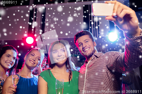 Image of friends with glasses and smartphone in club