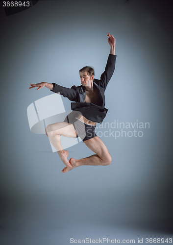 Image of The young attractive modern ballet dancer jumping on gray background