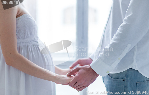 Image of The young couple  dressed in white standing at home