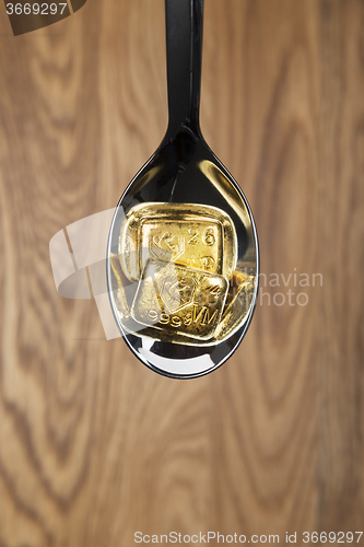 Image of gold bullions on spoon