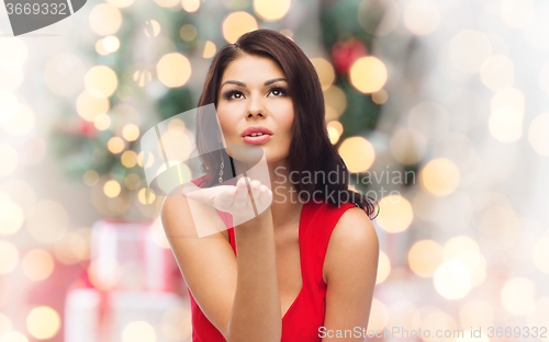 Image of woman sending blow kiss  over christmas lights