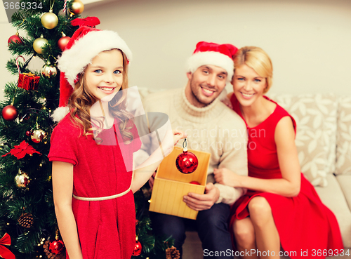 Image of smiling family decorating christmas tree