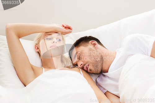 Image of couple sleeping in bed at home