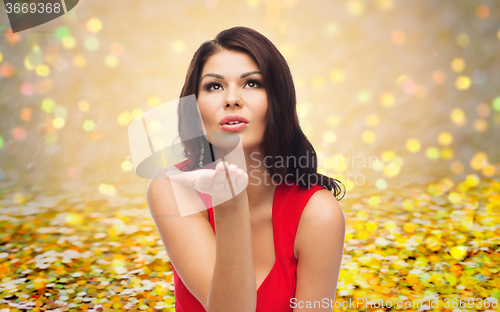 Image of beautiful woman sending blow kiss over glitter