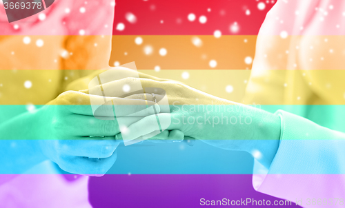 Image of close up of lesbian couple hands with wedding ring