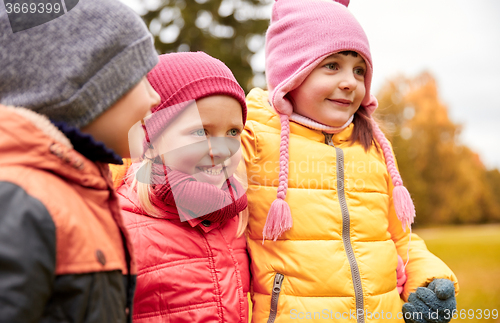 Image of group of happy children hugging in autumn park
