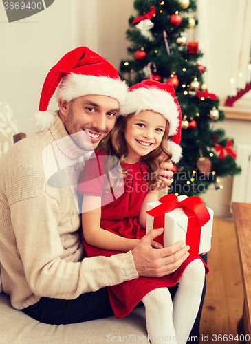 Image of smiling father and daughter holding gift box