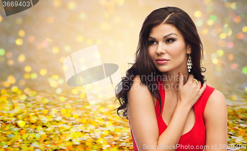 Image of beautiful sexy woman in red dress over glitter