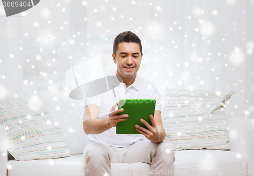 Image of smiling man working with tablet pc at home