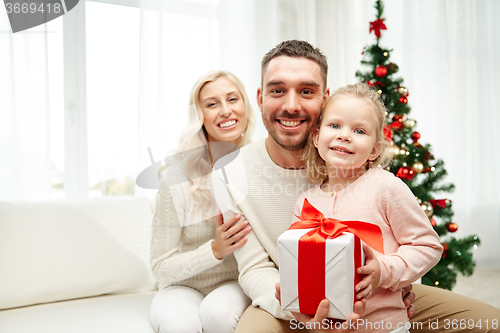 Image of happy family at home with christmas gift box