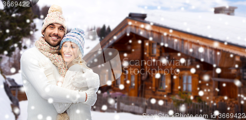 Image of smiling couple in winter clothes hugging outdoors