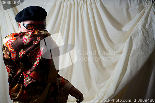 Image of man hiding behind kimono