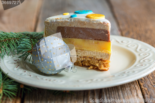 Image of Plate with a piece of cake and a Christmas ball.
