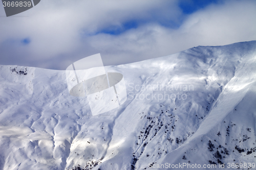 Image of Off-piste slope at evening and sky with clouds