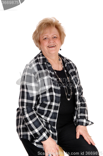 Image of Senior woman sitting on chair.