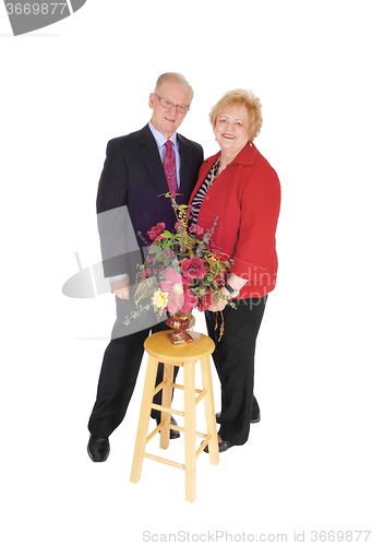 Image of Dressed up senior couple with flowers.
