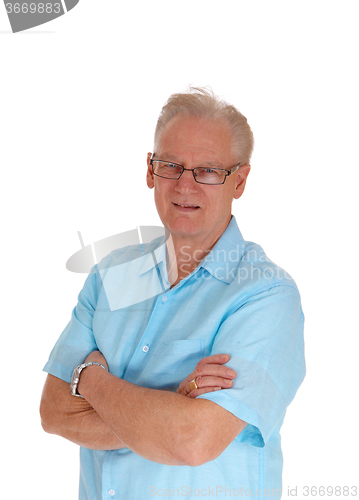 Image of Senior man standing with his arms crossed.