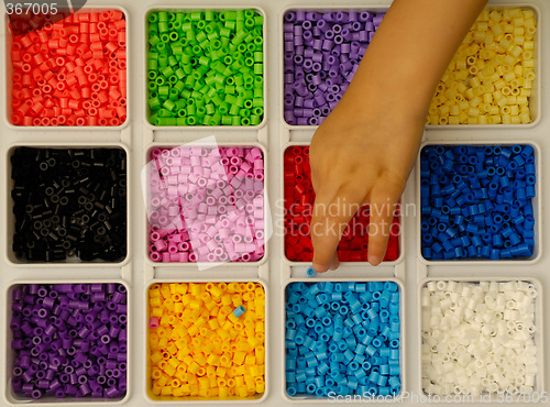 Image of Child playing with toy pearls