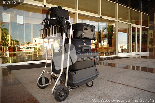 Image of Trolley with suitcases in front of hotel