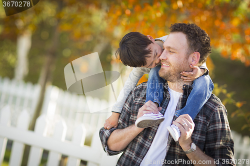 Image of Mixed Race Boy Riding Piggyback on Shoulders of Caucasian Father