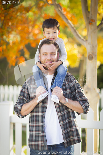 Image of Mixed Race Boy Riding Piggyback on Shoulders of Caucasian Father