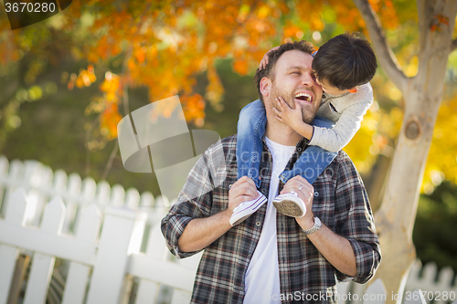 Image of Mixed Race Boy Riding Piggyback on Shoulders of Caucasian Father