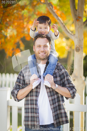Image of Mixed Race Boy Riding Piggyback on Shoulders of Caucasian Father