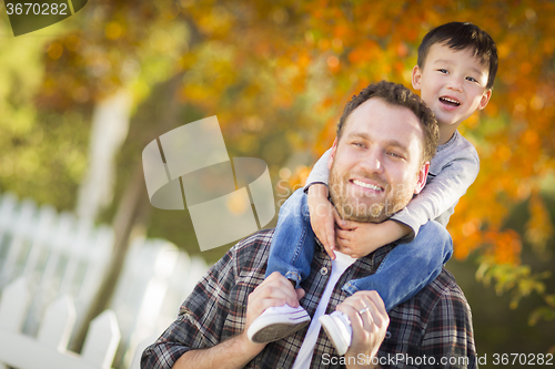Image of Mixed Race Boy Riding Piggyback on Shoulders of Caucasian Father