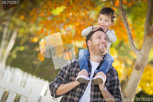 Image of Mixed Race Boy Riding Piggyback on Shoulders of Caucasian Father