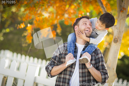 Image of Mixed Race Boy Riding Piggyback on Shoulders of Caucasian Father