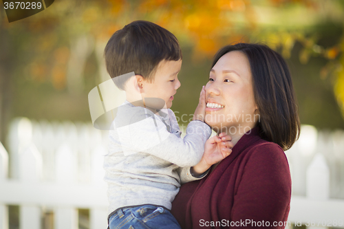 Image of Chinese Mom Having Fun and Holding Her Mixed Race Boy
