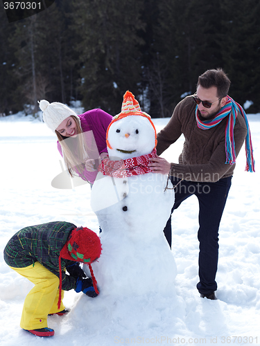 Image of happy family making snowman