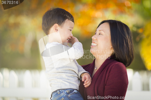 Image of Chinese Mom Having Fun and Holding Her Mixed Race Boy