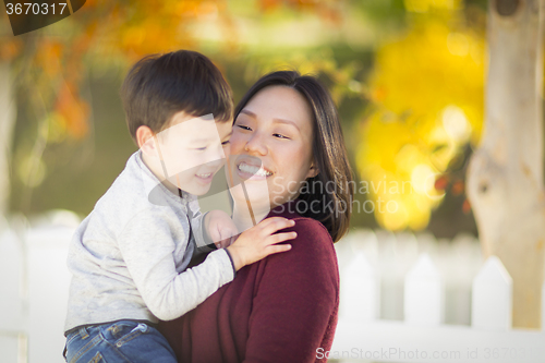 Image of Chinese Mom Having Fun and Holding Her Mixed Race Boy