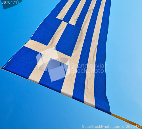 Image of waving greece flag in the blue sky and flagpole