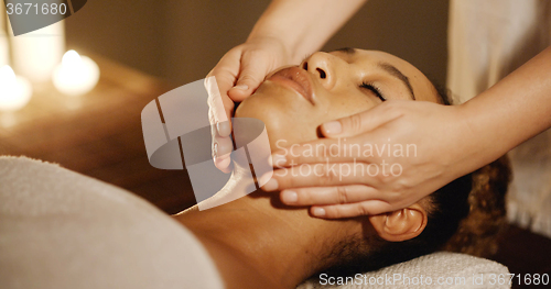 Image of Young Woman Enjoying Facial At Spa Salon