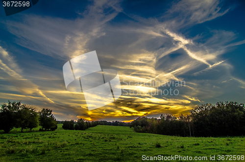 Image of sunset over green field farm land