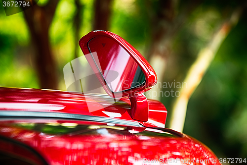 Image of open door and side view mirror of exotic luxury car