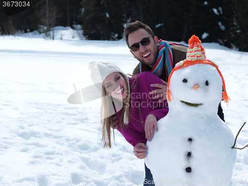 Image of portrait of happy young couple with snowman