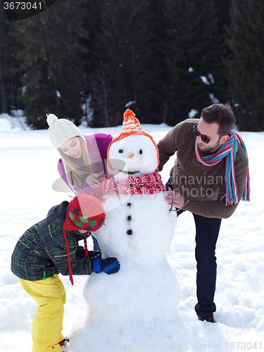 Image of happy family making snowman