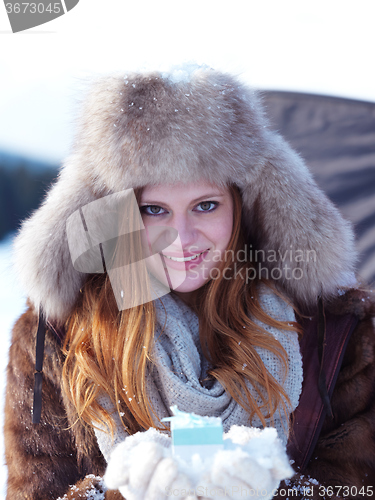 Image of portrait of  girl with gift at winter scene and snow in backgron