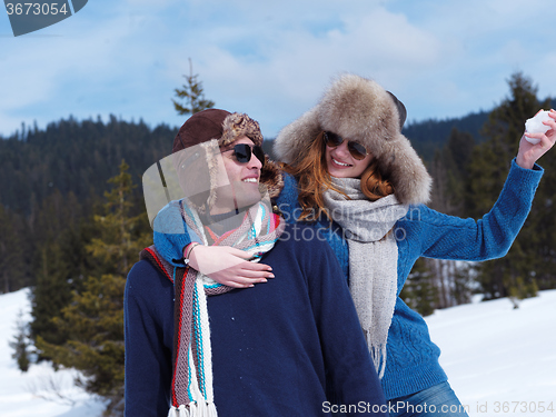 Image of happy young couple having fun on fresh show on winter vacation