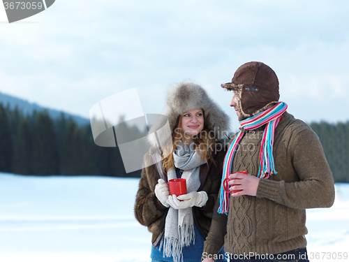 Image of happy young couple drink warm tea at winter