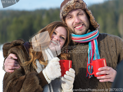 Image of happy young couple drink warm tea at winter