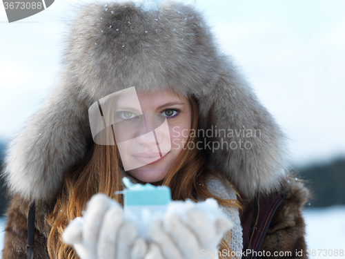 Image of portrait of  girl with gift at winter scene and snow in backgron