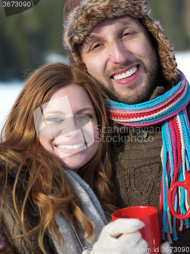 Image of happy young couple drink warm tea at winter