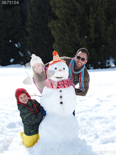Image of happy family making snowman