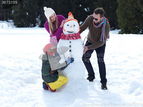 Image of happy family making snowman