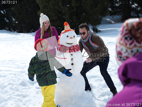 Image of happy family making snowman